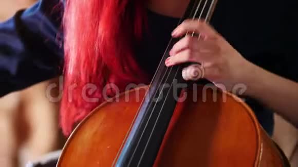 一个红头发的女人用蝴蝶结玩大提琴视频的预览图