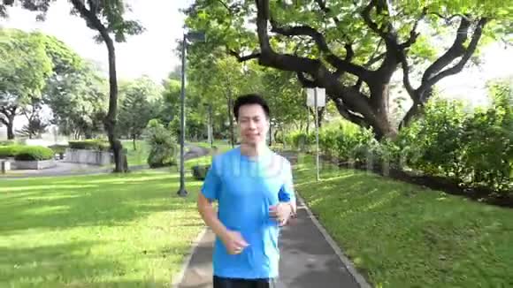 健康的生活方式穿着运动服的男人在日落时分在公园里跑步和看手表视频的预览图