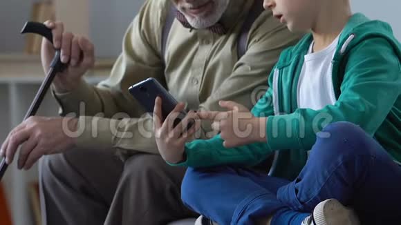 男孩子教爷爷如何使用智能手机应用程序交流视频的预览图