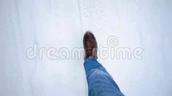 双脚俯视穿过雪地北方的冬天去森林的路视频的预览图
