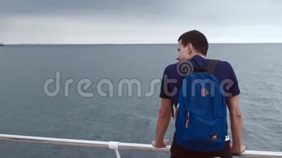 4K近距离拍摄一名男子从后面站在船上看海视频的预览图
