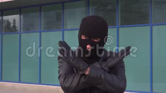罪犯小偷或戴面具的强盗正通过交叉双手来显示停车标志视频的预览图