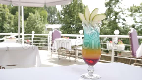 户外餐厅露台上酒保慢悠悠的镜头提供一杯夏季鸡尾酒配一片橘子和浆果视频的预览图