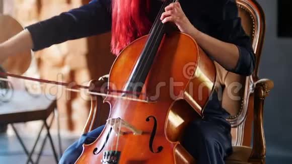 一个红头发的女人在演播室里演奏大提琴视频的预览图
