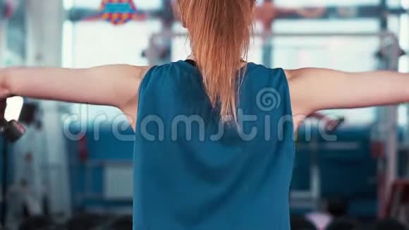 后视年轻的运动女孩锻炼与哑铃视频的预览图