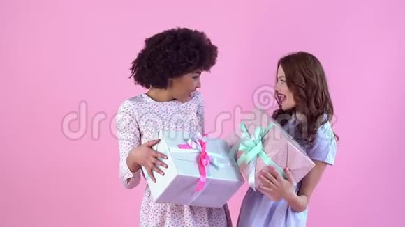 年轻女子工作室孤立于粉红色女子一天手捧礼盒视频的预览图