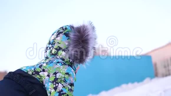 一个小孩子在冬季公园散步玩和微笑的宝宝爬上小山又掉下来了积极休息视频的预览图