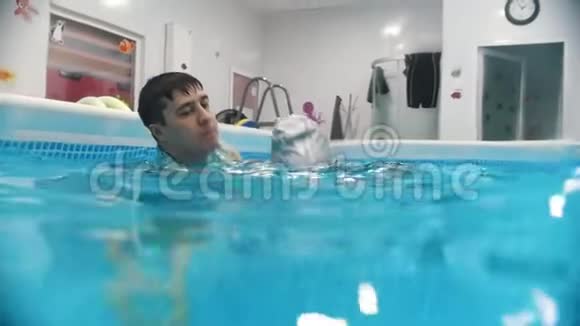 儿童脑瘫的水康复程序一个微笑的孩子从水中出现视频的预览图