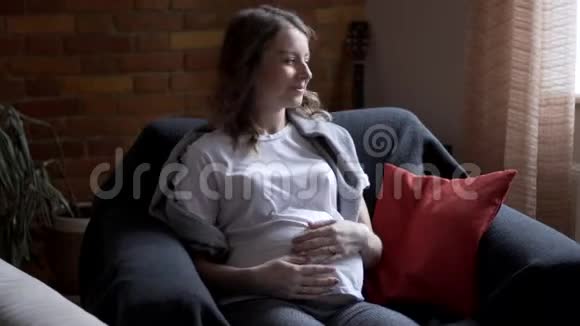 玩耍的男孩和怀孕的母亲坐在扶手椅上视频的预览图