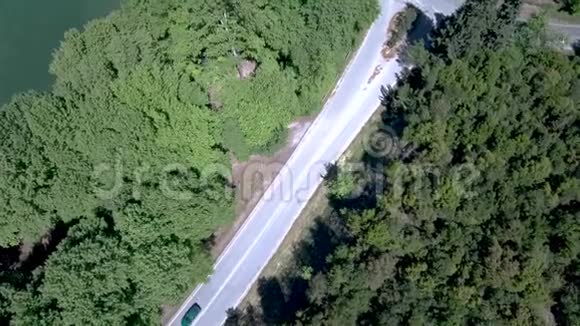 空中俯瞰希腊北部树木之间的山地乡村公路无人机向下移动视频的预览图