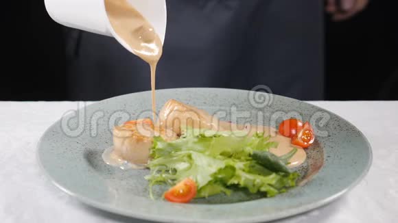 葱花奶油正被浇到生菜和扇贝上准备食物做健康的食物慢慢视频的预览图