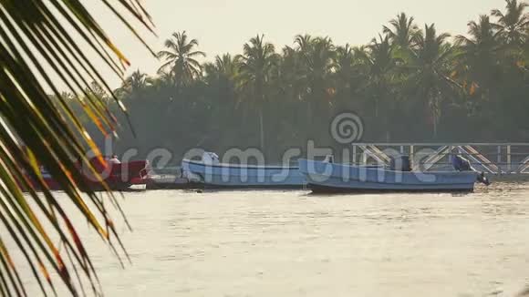 热带岛屿有椰子棕榈树靠近大海的木墩和为暑假旅行准备的摩托艇视频的预览图