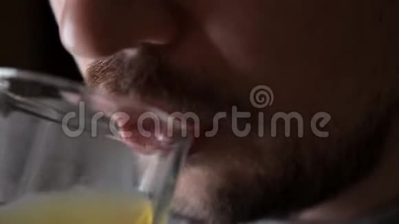 男人喝一杯橙色碳酸饮料特写视频的预览图