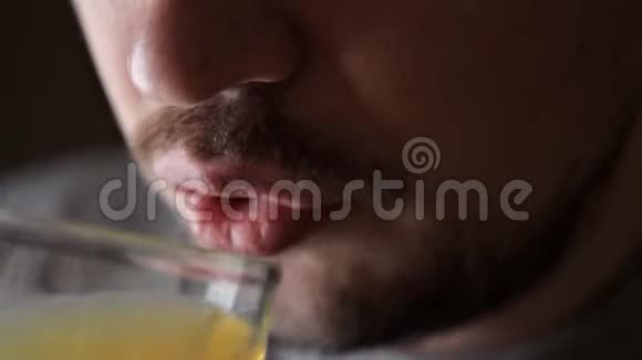 男人喝一杯橙色碳酸饮料特写视频的预览图