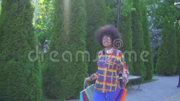 性格开朗的非裔美国妇女留着非洲发型购物后带着包裹视频的预览图