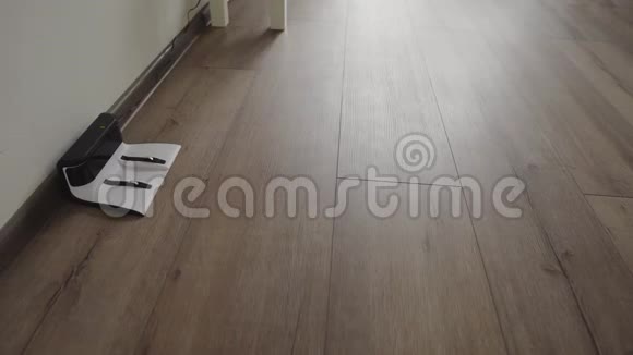 一个机器人吸尘器滑过一个现代客厅并拉进充电4K视频的预览图
