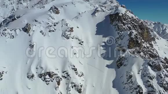 一个覆盖着大雪的山脉有着巨大的岩石山空中拍摄的画面是4k视频的预览图