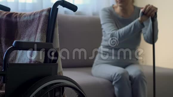 悲伤的老太太看着轮椅感到孤独和被遗弃沮丧视频的预览图