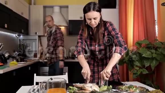 一对年轻夫妇煮了晚餐沙拉蔬菜一个年轻女孩切了炸鸡视频的预览图