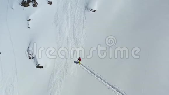 一个滑雪板上的人正在一座覆盖着雪的山上转过身空中射击4k视频的预览图