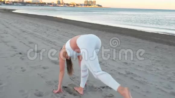日出时年轻女子在沙滩上做不同姿势的瑜伽伸展运动视频的预览图
