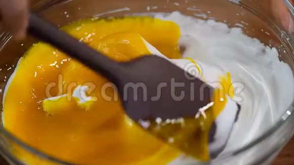 在玻璃碗中混合奶油时加入蛋黄家庭面包店家里烘焙的原料视频的预览图
