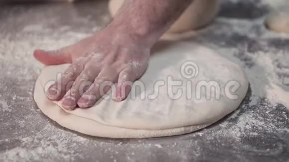 面包师在厨房里用手把比萨饼面团慢动作视频的预览图