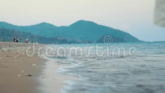 美丽的女孩走在海边的背景山少女海滩视频的预览图