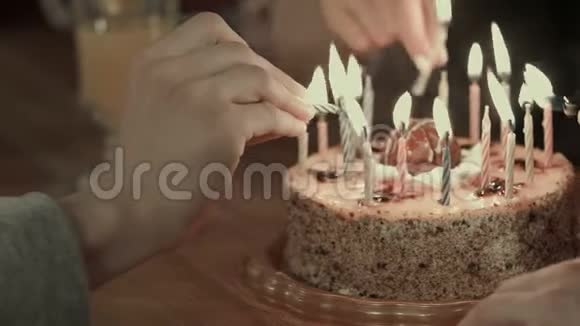 两个人在生日蛋糕上点燃蜡烛视频的预览图