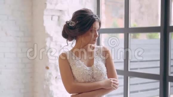 女孩穿着一件浅白色豪华婚纱独自站在宽敞的房间里内部是斯堪的纳维亚半岛视频的预览图