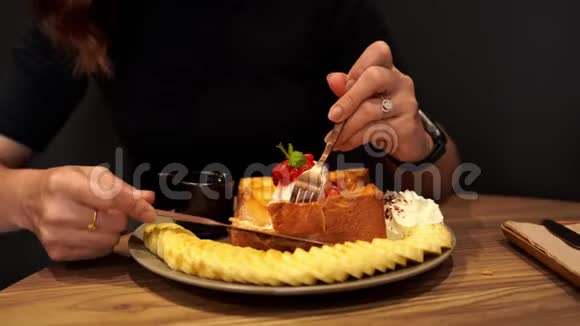 双手拿着叉子和刀在蜂蜜吐司上切视频的预览图