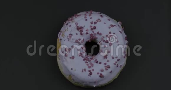 甜甜甜圈在黑色背景上旋转上景美味新鲜的甜甜圈视频的预览图