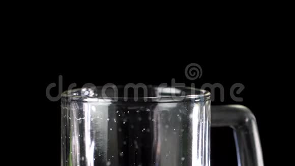 将啤酒倒入玻璃中泡沫泡在黑暗的背景下视频的预览图