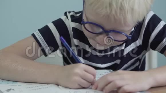 一个穿条纹T恤的男生做作业视频的预览图