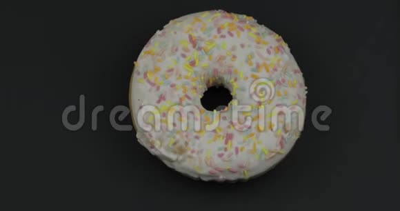 甜甜甜圈在黑色背景上旋转上景美味新鲜的甜甜圈视频的预览图