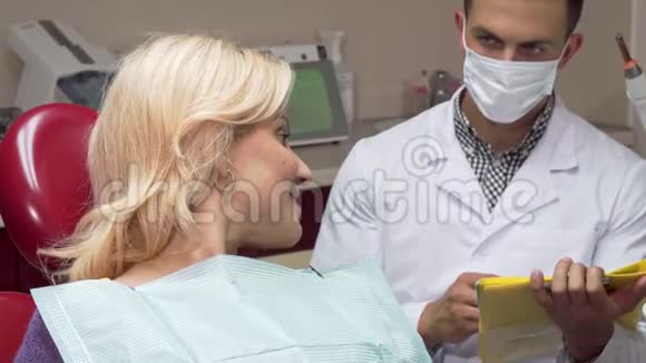快乐的女性病人坐在牙科椅上竖起大拇指视频的预览图