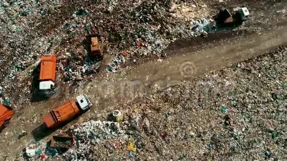 巨大的橙色垃圾车在碎片之间移动填埋现场的工作设备视频的预览图