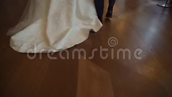 新郎新娘在室内的木地板上散步视频的预览图