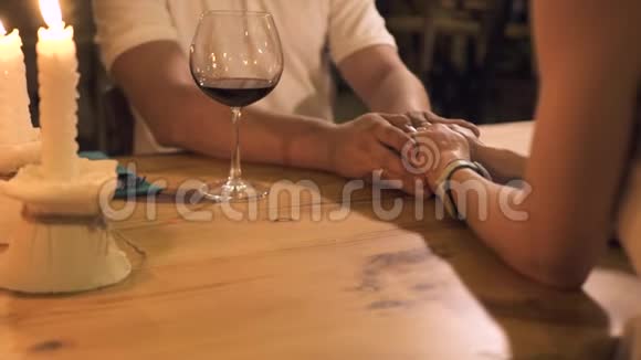 恋爱中的情侣在餐厅的浪漫约会中手捧蜡烛和酒杯男子和妇女视频的预览图