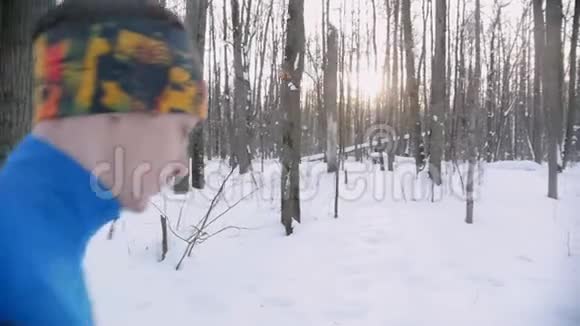 清晨在冬林中奔跑的青年男女侧视图视频的预览图