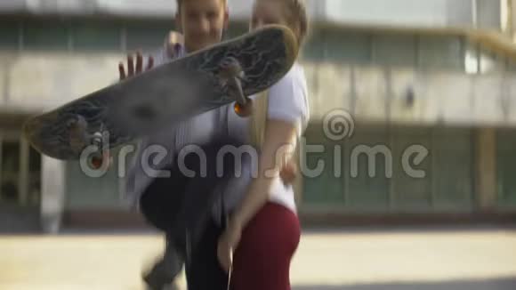 溜冰者用木板做把戏拥抱女士看镜头亚文化视频的预览图