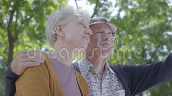 一对恋爱中的成熟夫妇坐在公园的长凳上的肖像可爱的女人和老人在一起投标视频的预览图