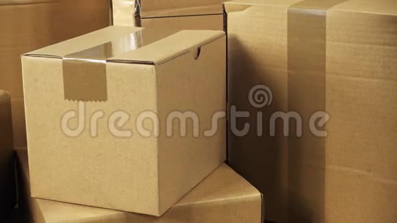 相机旋转棕色纸箱包裹堆放在木制办公桌上准备装运或刚刚交付视频的预览图