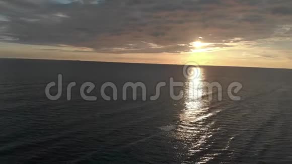 鸟瞰从海上返回美妙的黄昏和海浪拍打在海岸上视频的预览图
