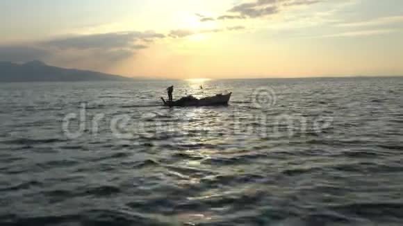 金黄夕阳下漂浮的渔船视频的预览图