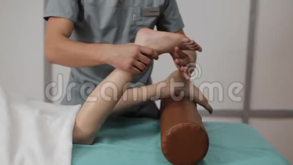 替代药物治疗理疗师在理疗办公室用按摩锻炼小女孩的腿视频的预览图