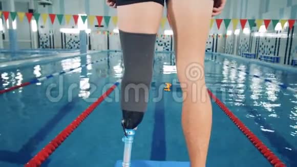 残疾游泳运动员站在游泳池附近靠近视频的预览图