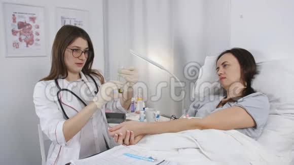 女医生准备一个注射器用于注射药物给躺在床上的病人视频的预览图