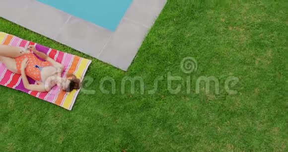 穿泳装的女人在后院的池边放松视频的预览图