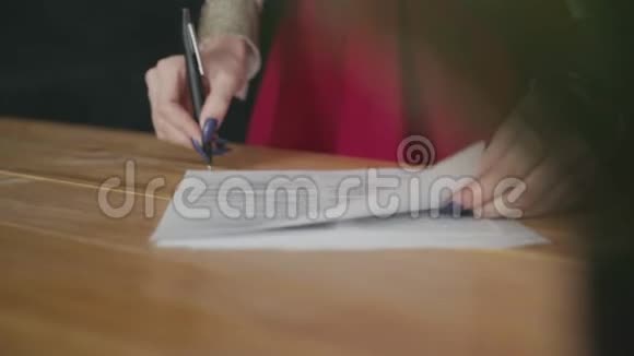 一个女人的手签文件的特写镜头视频的预览图